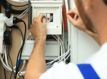 Close-up of hands installing an electrical outlet in a panel