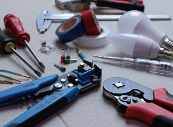 Flat lay of electrician hand tools including pliers, screwdrivers and a wire stripper